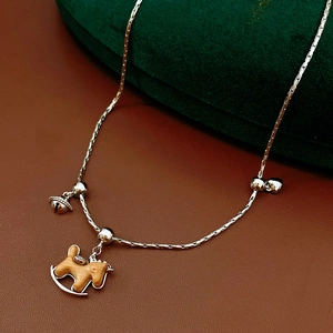 Vue détaillée du collier à bascule avec clochette sur un écrin en velours vert