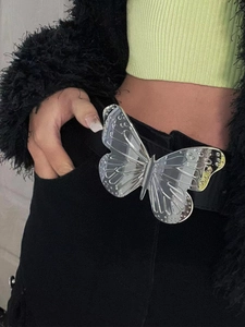 Close-up of a glossy silver butterfly buckle on a black faux leather waist belt
