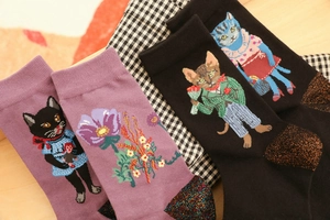 Close-up of cotton socks with cat patterns, floral motifs and metallic heel detailing
