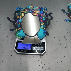 Detail showing the Medusa acrylic suncatcher weighing approximately 106.1g on a scale