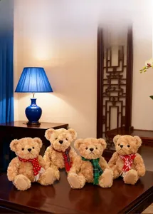 Close-up of four plush teddy bears wearing different patterned scarves in a warm room