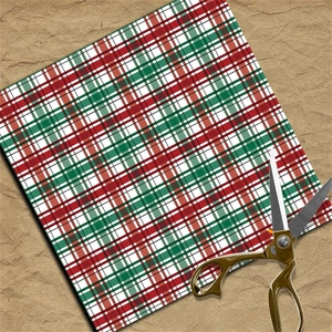 Detail view of red and green tartan decorative paper with scissors on vintage background