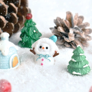 Miniature resin Christmas snowman and snow house figurines in a festive winter scene