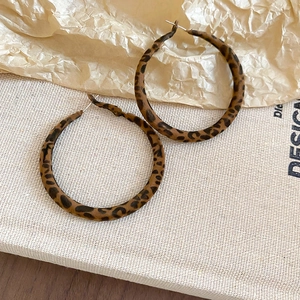 Macro shot of vintage leopard print velvet hoop earrings with elegant metal texture