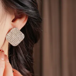 Elegant square silver earrings with full sparkling pavé zircons worn by a female model