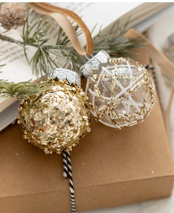 Close-up of golden and transparent 6cm Christmas ornaments with sequins and ribbons
