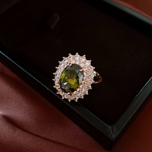 Detail of vintage oval green gemstone ring with diamonds in a black velvet gift box