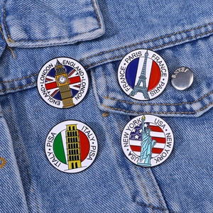 Set of four metal enamel landmark badges including Big Ben and Eiffel Tower on denim