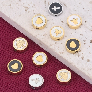 Macro view of stainless steel enamel beads with heart cross and angel motifs for DIY jewelry