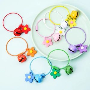 Flat lay of colorful flower charms with metal bells and wire rings for bags