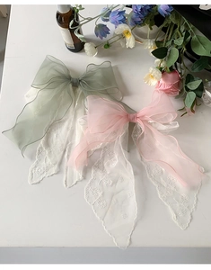 Elegant large mesh and lace bow hair clips in pink and green colors on white background