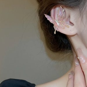 Detail of elegant pink butterfly ear cuff with gold trim worn on a model's ear