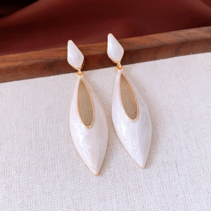 Gros plan détaillé de boucles d'oreilles gouttes dorées avec incrustation nacrée