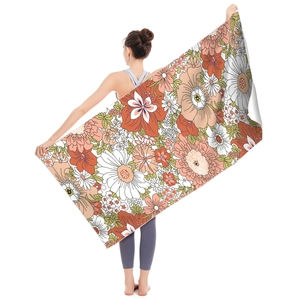Close-up of microfiber beach towel featuring vintage floral patterns in orange and green