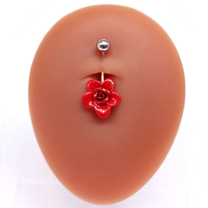 Piercing de nombril en argent avec un pendentif rose rouge sur un modèle couleur chair