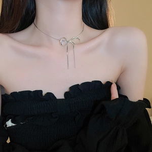 Elegant silver bow pendant necklace worn on neck highlighting minimalist style
