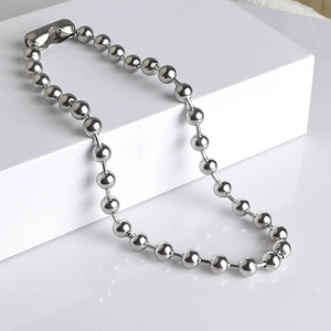 Polished silver stainless steel ball chain necklace displayed on a white minimalist pedestal