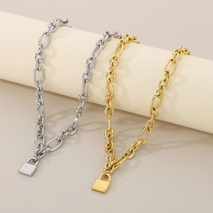 Detail of chunky gold and silver chain link necklaces with classic metal padlock pendants