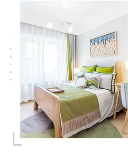 Chambre de style nordique avec couverture en tricot vert clair et coussins géométriques
