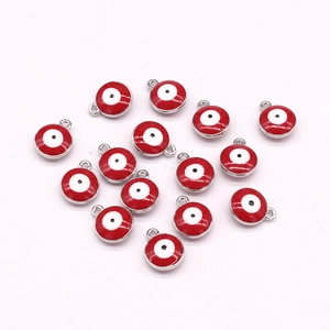 Macro detail of red enamel evil eye charms with gold bezels for DIY jewelry making