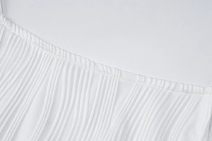 Close-up of white fringe texture and stitch detail on a slim-fit summer dress