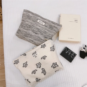 Detail of minimalist fabric makeup bags with 'simple wish' label and floral pattern