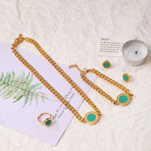 Flat lay of gold stainless steel jewelry set with green malachite geometric pendants