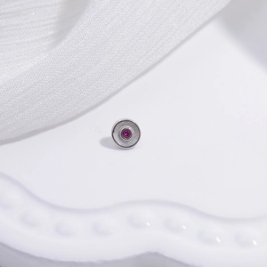 S925 sterling silver connector with pink gemstone on white knit fabric background