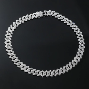 Detail shot of silver hip-hop Cuban chain with iced-out rhinestones on black background
