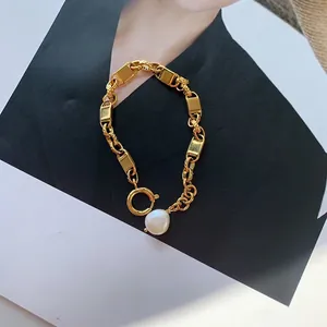 Détail d'un bracelet chaîne plaqué or 18k avec maillons rectangulaires et perle