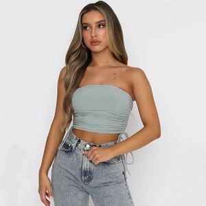 Détail de haut bandeau vert clair avec cordons de serrage latéraux et tissu plissé