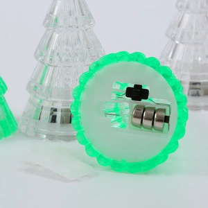 Detail of glowing Christmas tree LED light base showing battery compartment and power switch
