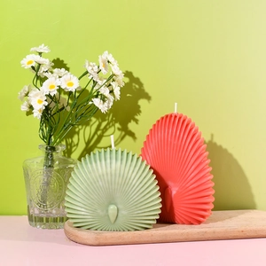 Dettaglio di candele a forma di conchiglia con delicate strisce radiali su vassoio
