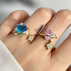 Detail of gold open rings with blue and pink heart zircons in star themed design