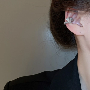 Detail of silver snake-scale ear cuff with sparkling pavé zircons worn on the ear