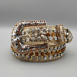 Macro view of carved silver buckle and amber rhinestones on gold glitter western belt