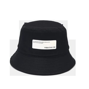Close-up of a black cotton bucket hat featuring a white fabric patch with typography print