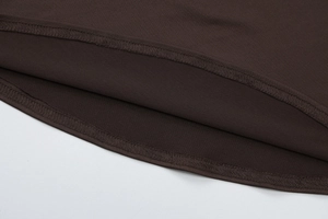 Detailed close-up of the double-needle stitching and hem on a dark brown knit dress