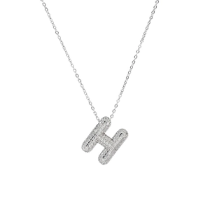Close-up of sparkling zircon-encrusted bubble H-letter pendant on a silver chain