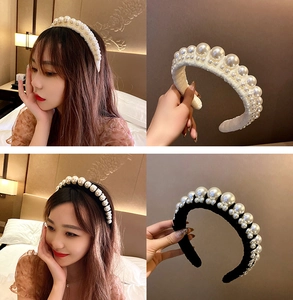 Detail of elegant pearl headband featuring white and black fabric with beaded texture
