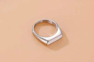 Detail of a vintage oval stainless steel ring with white resin inlay and polished finish