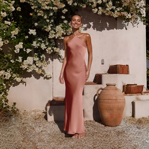 Detailed texture of dusty rose satin fabric on a backless sleeveless maxi dress