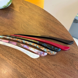 Detail of handcrafted acetate hair sticks in six colors with gold France Handmade label