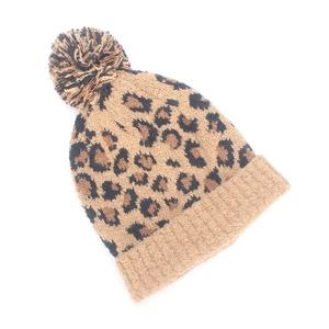 Close-up of leopard print knit beanie featuring a soft faux fur pompom and ribbed cuff