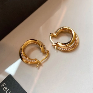 Double layered twisted gold hoop earrings with sparkling pavé crystals for a luxury look