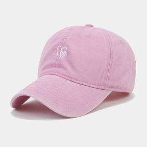 Close-up of pink washed cotton baseball cap with white heart embroidery detail