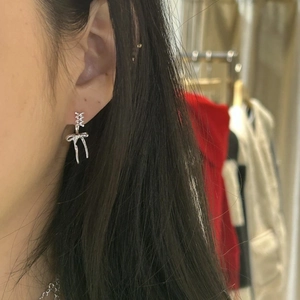 Close-up of minimalist silver bow stud earring worn by a model for a daily style