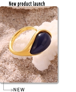 Macro detail of teardrop blue resin stone set in 18k gold-plated stainless steel ring