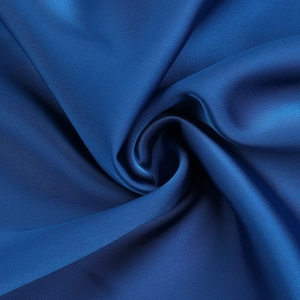 Detail of royal blue satin dress fabric showing luxurious texture and spiral drape