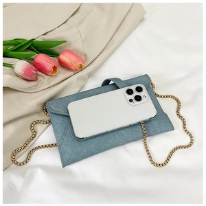 Blue denim texture envelope bag detail showing interior size comparison with smartphone